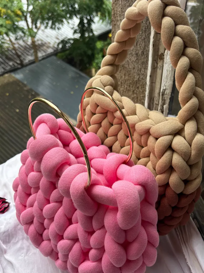 Roze i bež Jumbo torbe sa zlatnim obručima u prozoru